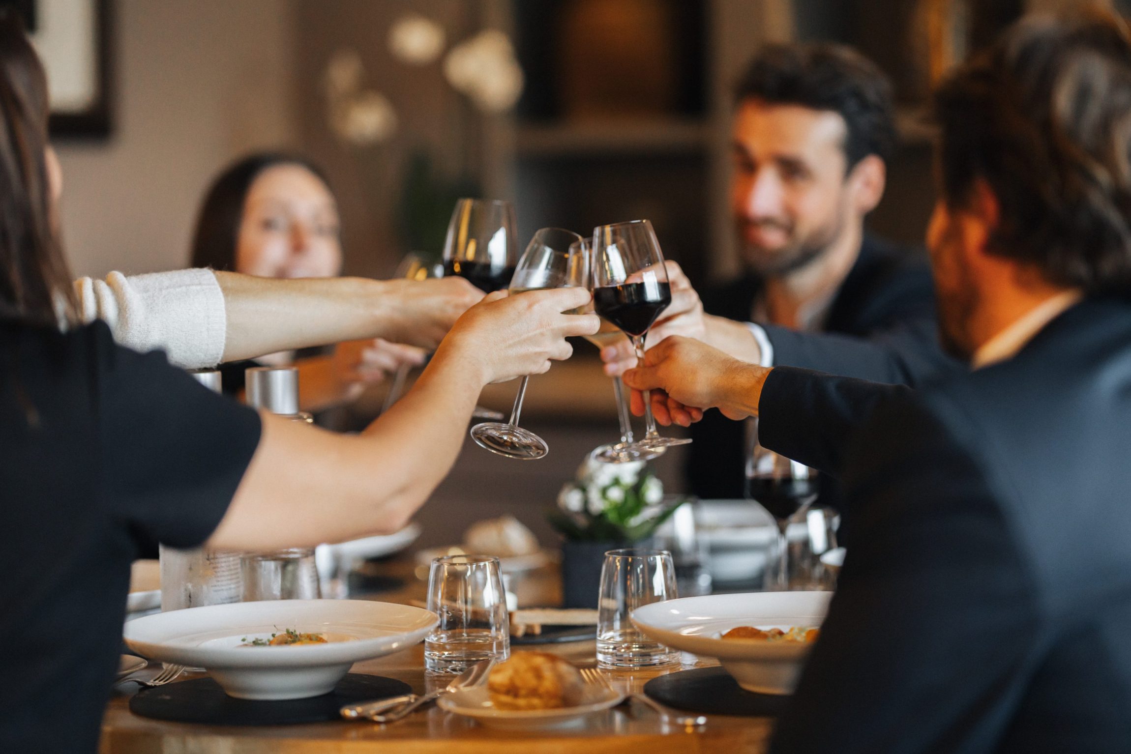 Dîner d’entreprise convivial dans le Morbihan avec des collaborateurs portant un toast au restaurant – Destination Yves Rocher